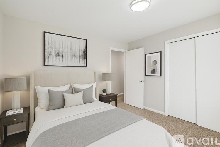 A bedroom with a large bed and a painting on the wall.