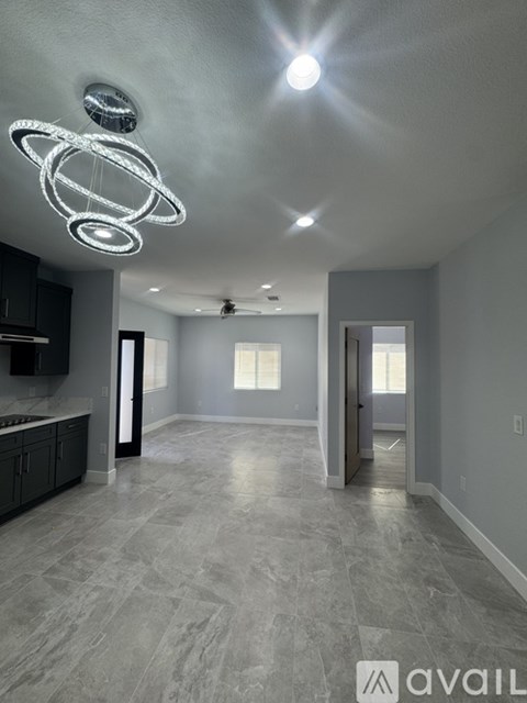 A modern kitchen with a large island and a ceiling fan.