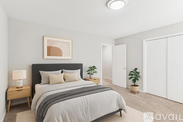 A bedroom with a large bed and a painting on the wall.