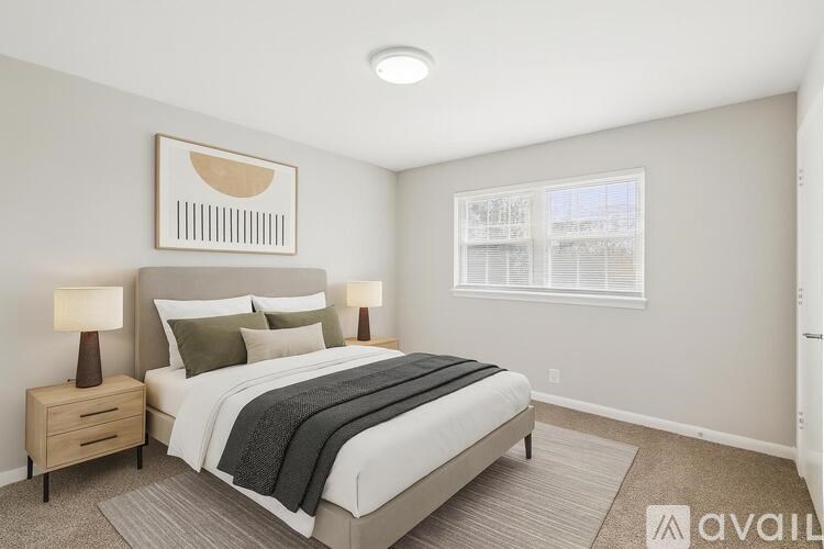 A bedroom with a bed, nightstands, and a window.