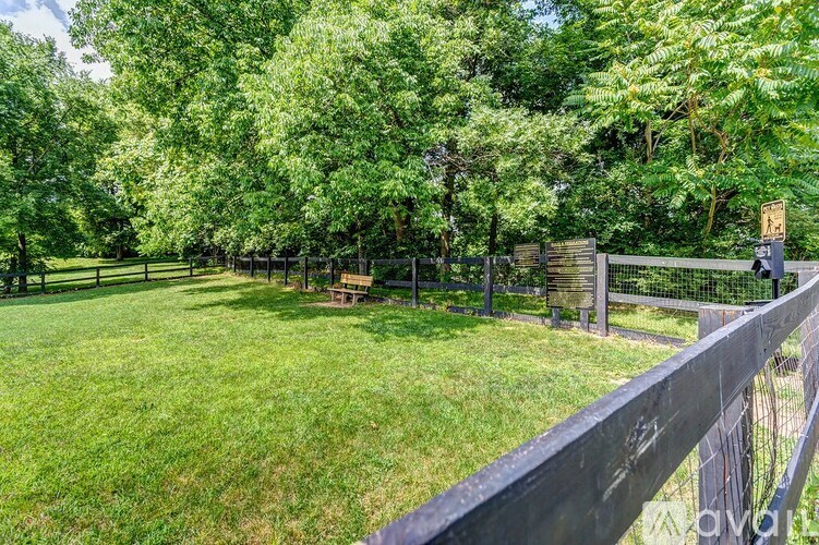 A backyard with a fence and a green lawn.