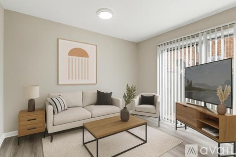 A living room with a grey couch, a coffee table, a lamp, a potted plant, and a television.