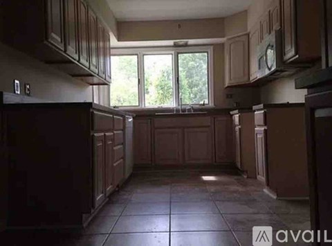 A kitchen with brown cabinets and a tiled floor.