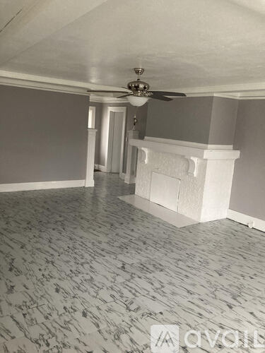 A room with a ceiling fan and a fireplace.
