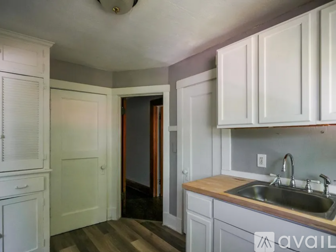 A kitchen with white cabinets and a sink.