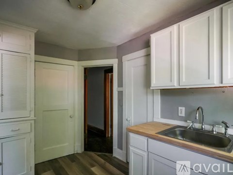 A kitchen with white cabinets and a sink.