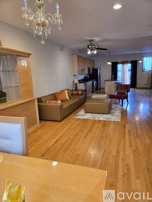 A living room with a couch, chairs, and a dining table.