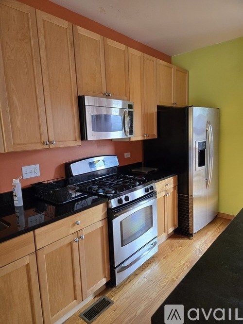 A kitchen with wooden cabinets and a black countertop.