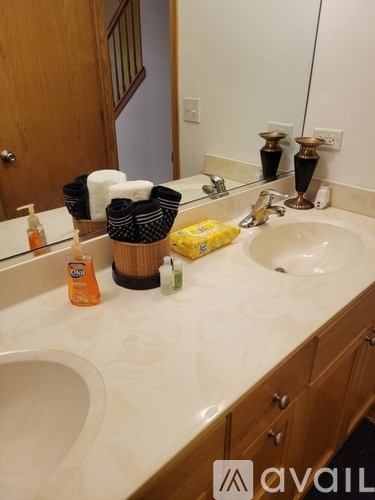 A bathroom sink with a basket of towels and a bottle of lotion.