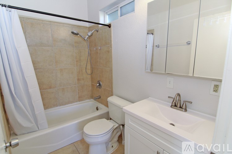 A bathroom with a toilet, sink, and bathtub.