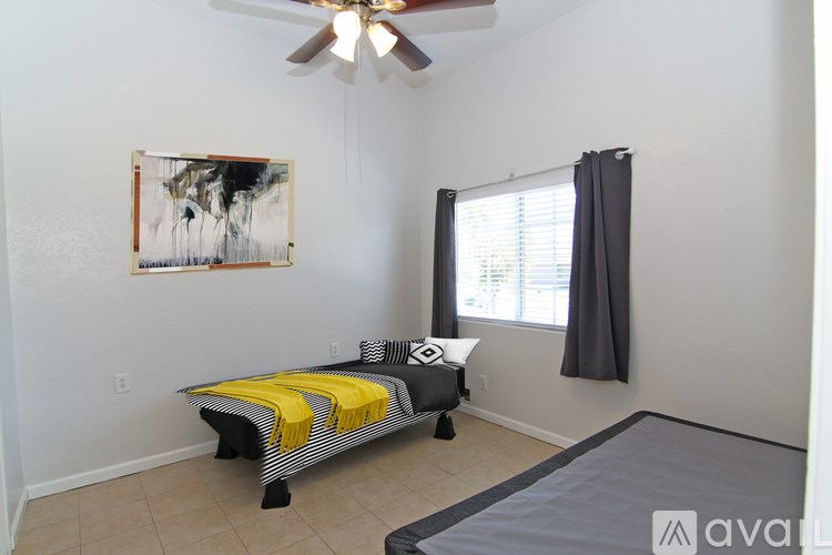A bedroom with a bed and a ceiling fan.