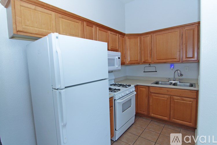 A kitchen with a white refrigerator and wooden cabinets.