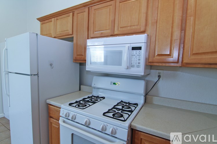 A white refrigerator and a white microwave are on a kitchen counter.