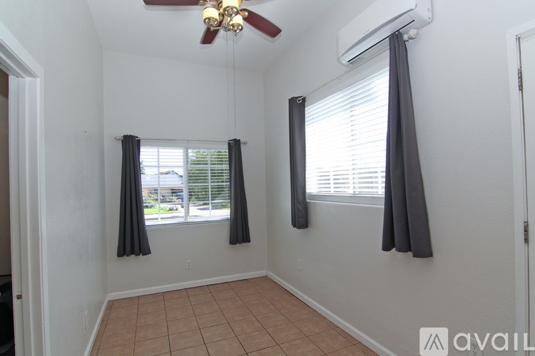 A room with a ceiling fan and air conditioner unit.
