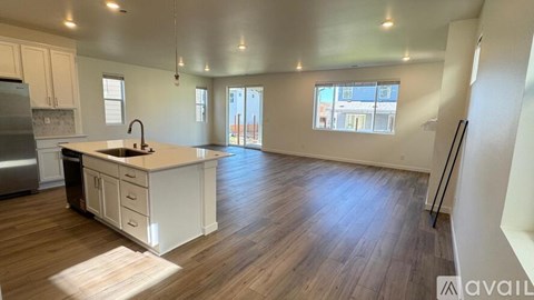 A kitchen with white cabinets and a wooden floor.