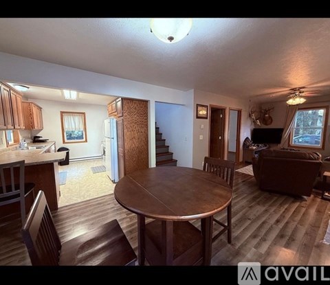A living room with a brown couch and a wooden table.