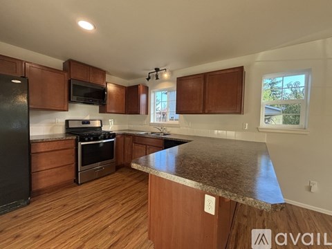 A kitchen with wooden cabinets and a granite countertop.