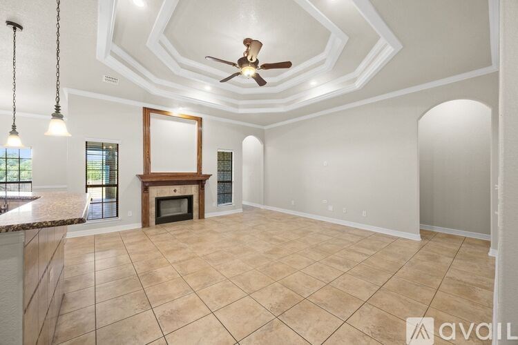 A spacious room with a fireplace and a ceiling fan.