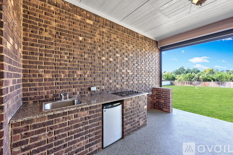 A kitchen area with a brick wall and a window.