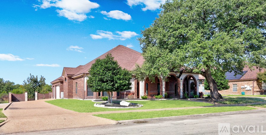 A house with a driveway and a tree in front.