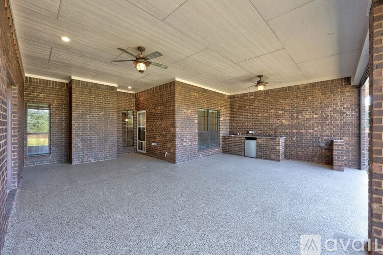 A spacious room with brick walls and a ceiling fan.