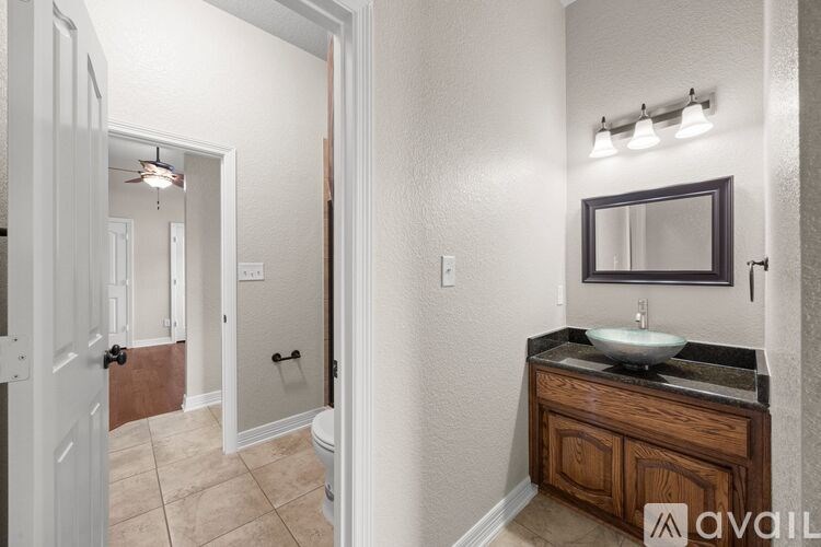 A bathroom with a sink, mirror, and toilet.