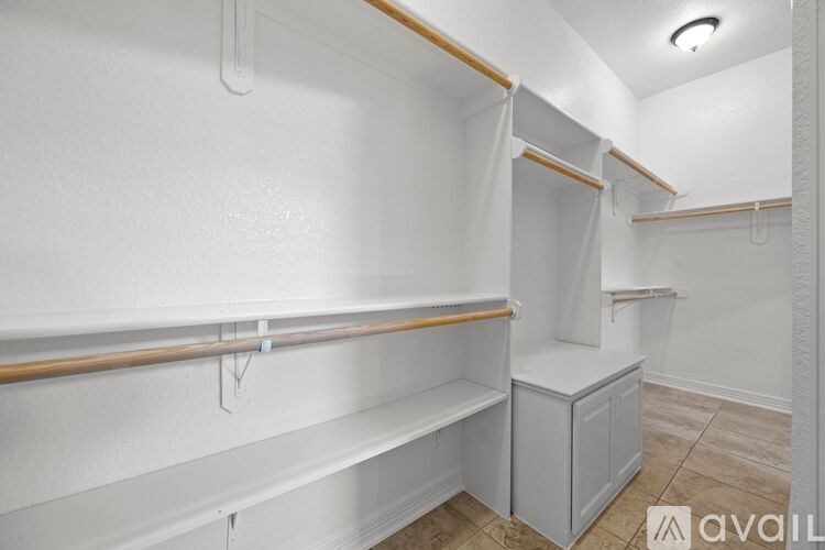 A white bathroom with a towel bar and a cabinet.