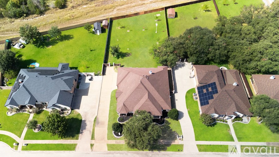 A bird's eye view of a neighborhood with houses and green lawns.