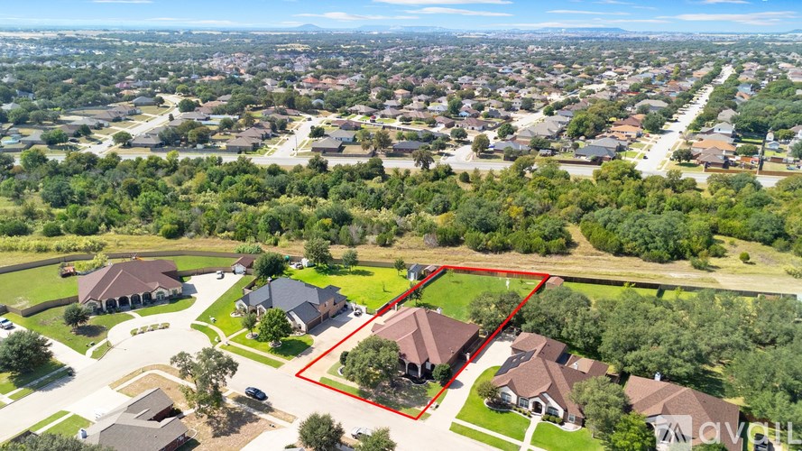 A bird's eye view of a residential area with a red outlined property.