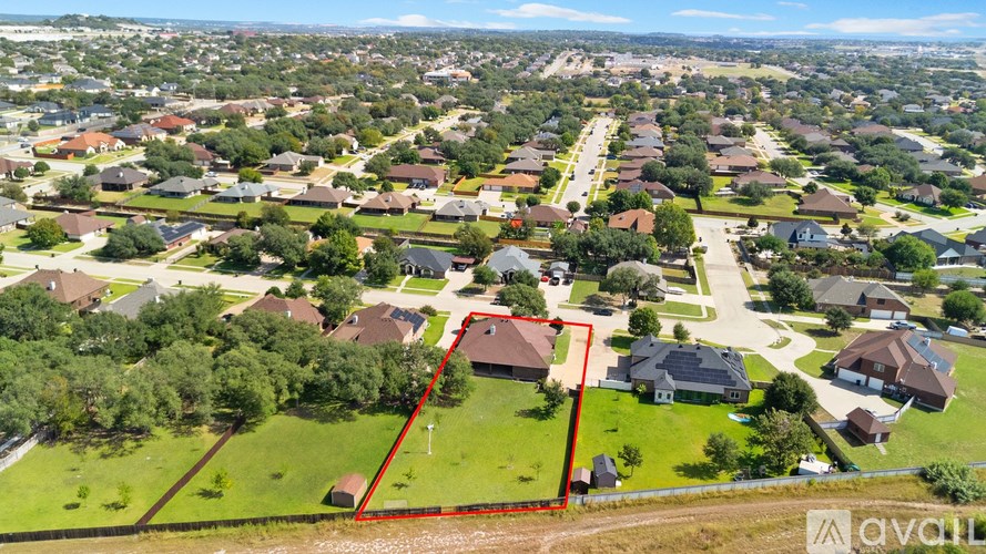 A bird's eye view of a neighborhood with a red line drawn on a property.