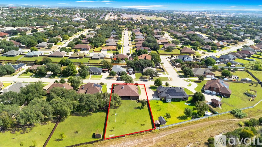 A bird's eye view of a residential area with a red outlined property.