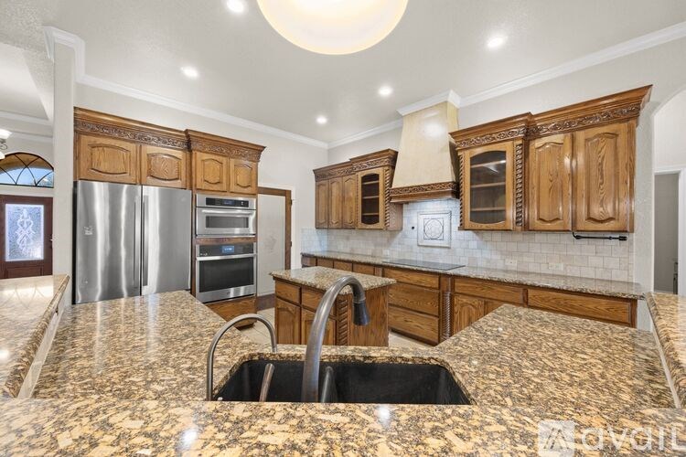 A kitchen with granite countertops and wooden cabinets.