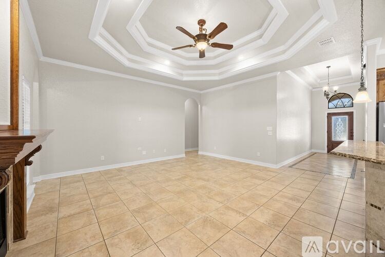 A spacious room with a ceiling fan and tiled flooring.