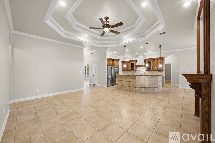 A spacious room with a fan and a bar area.