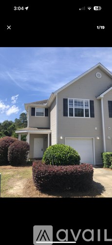 A house with a grey roof and a white garage door.