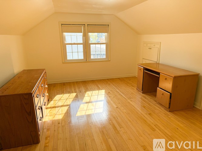 A room with wooden flooring and a window with two panes of glass.
