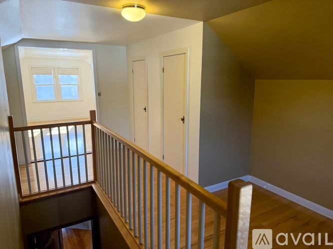 A wooden staircase with a white door and window.