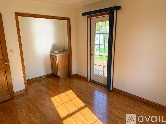 A room with wooden floors and a large mirror on the wall.