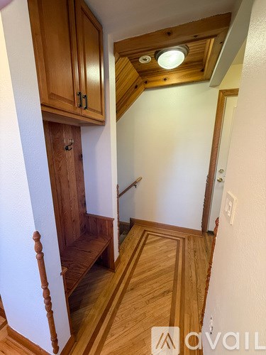 A hallway with wooden floors and a wooden staircase.