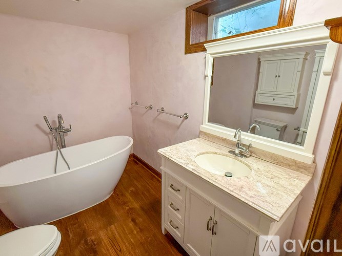 A bathroom with a white tub and sink vanity.
