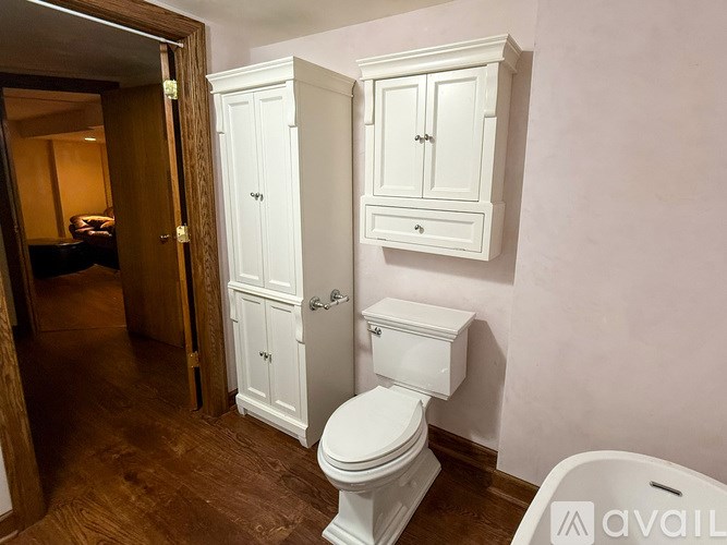 A white toilet is in a bathroom with a cabinet and medicine cabinet above it.