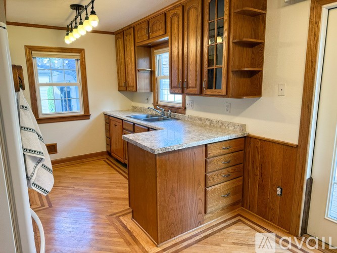 A kitchen with wooden cabinets and a marble countertop.
