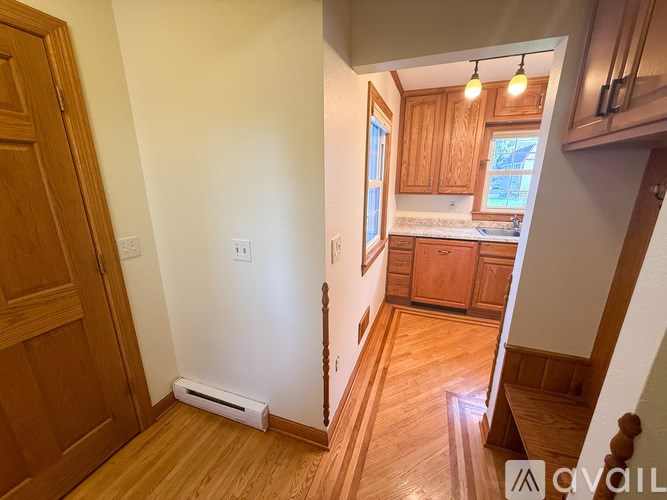 A room with wooden floors and a white wall with a window.