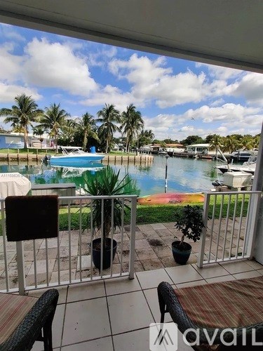 A balcony overlooks a marina with boats and palm trees.