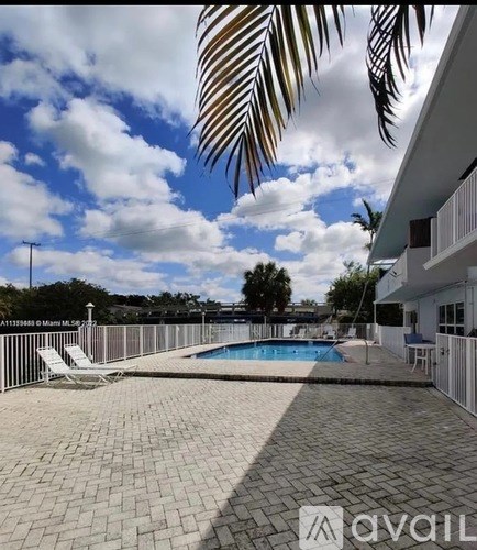 A patio with a pool and a palm leaf.
