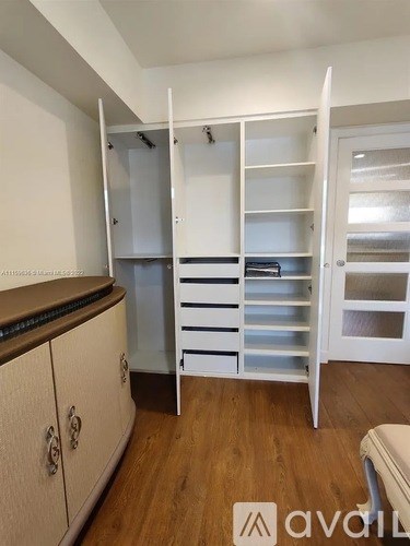 A white pantry with a white chair and a white cabinet.