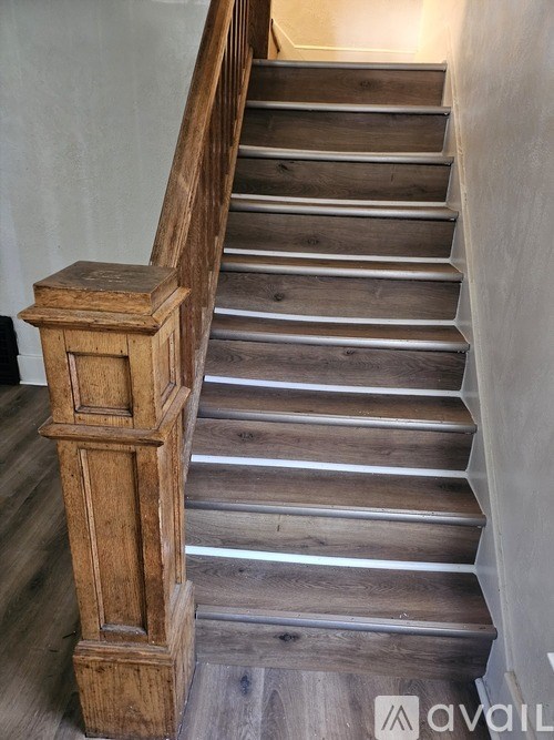 A wooden staircase with a wooden handrail.