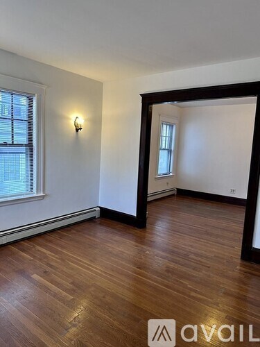 A room with wooden floors and a window with blinds.