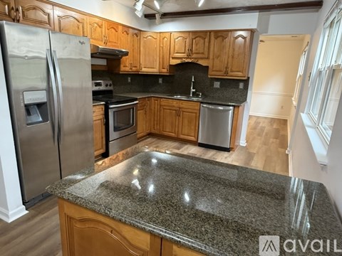 A kitchen with wooden cabinets and granite countertops.