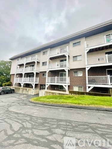A parking lot in front of a multi-story apartment building.